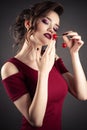 Elegant girl in red dress with cherry in hands Royalty Free Stock Photo