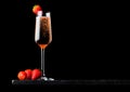 Elegant glass of pink rose champagne with strawberry on top and fresh berries on black marble board on black background. Space for Royalty Free Stock Photo