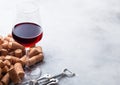 Elegant glass of red wine with corks and opener on stone kitchen table background Royalty Free Stock Photo