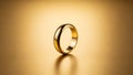 Elegant Gold Ring on Reflective Surface with Warm Background Royalty Free Stock Photo