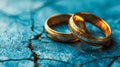 Close-up of intertwined gold wedding bands on textured blue surface Royalty Free Stock Photo