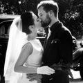 elegant gorgeous bride and handsome stylish groom kissing on background of black car. unusual luxury wedding couple in retro Royalty Free Stock Photo