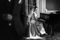 Elegant gorgeous bride playing the fortepiano in rich old room a