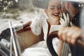 elegant gorgeous bride smiling and handsome stylish groom kissing her in car. unusual luxury wedding couple in retro style. roman