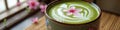 Elegant green tea latte with pink flower art in cozy setting Royalty Free Stock Photo
