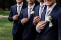 Elegant groom`s men with sttlish flowers tie. white Flowers in buttonhole, the groom`s men are dressed in a dark suit. Wedding d