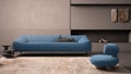 Elegant grunge living room with plaster walls and floor, fireplace. Blue sofa with pillows, carpet, fluffy armchair, side tables,