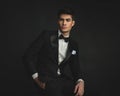 elegant handsome young man wearing black suit looking to side Royalty Free Stock Photo