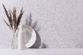 Elegant home decor with white ceramic crockery, glass bottle and grey bouquet with dried grass on white wood table, copy space.