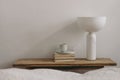 Elegant home, interior. Cup of coffee, books and modern marble geometric lamp on vintage teak wooden bench, table. Empty