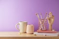 Elegant home office table with coffee cup, notebook and pencils over purple background. Back to school concept Royalty Free Stock Photo