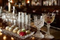 elegant hors doeuvres next to crystal cocktail glasses on a bar