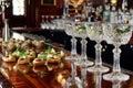 elegant hors doeuvres next to crystal cocktail glasses on a bar