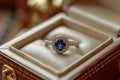 open jewelry box with blue sapphire ring and diamonds