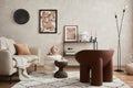 Elegant interior of living room with beige sofa, black console, brown creative armchair, modern lamp, mock up poster frame. Royalty Free Stock Photo