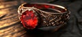Elegant intricately designed ring featuring a large red gemstone on a dark textured surface Royalty Free Stock Photo