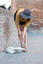 Elegant Italian woman with hat keeps her cat on a leash