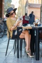 Elegant Italian woman with hat and glasses pets her cats