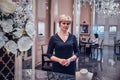 Elegant jewellery boutique`s owner is waiting for customers in her beautiful posh shop