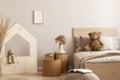 Elegant kid`s bedroom with wooden furniture and toys, real photo with copy space on empty wall Royalty Free Stock Photo