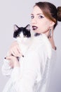 Elegant lady holding black and white cat with yellow eyes Royalty Free Stock Photo