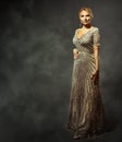 Elegant Lady in Long Glitter Dress. Fashion Adult Woman in Evening Sequin Gown over dark Background. Beautiful Mature Model Royalty Free Stock Photo