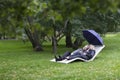 Elegant lady walking in a beautiful park under umbrella Royalty Free Stock Photo