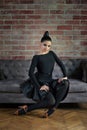 Elegant latin woman dancers in black dresses posing near sofa