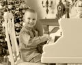 Little boy playing on a white Grand piano. Royalty Free Stock Photo