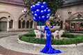 Elegant luxury fashion. Glamour, stylish elegant woman in long gown sequin dress is holding bunch of balloons. Female model in Royalty Free Stock Photo