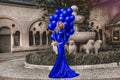 Elegant luxury fashion. Glamour, stylish elegant woman in long gown sequin dress is holding bunch of balloons. Female model in Royalty Free Stock Photo