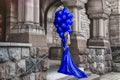 Elegant luxury fashion. Glamour, stylish elegant woman in long gown sequin dress is holding bunch of balloons. Female model in Royalty Free Stock Photo