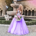 Elegant luxury fashion. Glamour, stylish elegant woman in amazing long gown dress. Female model in lilac long dress in the city. Royalty Free Stock Photo