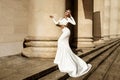 Elegant luxury fashion. Glamour, stylish elegant woman in long gown white dress is posing outdoor. Female model in amazing long Royalty Free Stock Photo