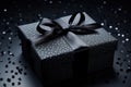 Elegant luxury present gift box with black ribbon bow on isolated black background. Shopping boxing day, Black friday