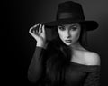 Elegant makeup woman in fashion hat posing on dark shadow background. CLoseup portrait. Black and white portrait Royalty Free Stock Photo