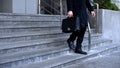 Elegant male in suit with briefcase walking downstairs office building, business Royalty Free Stock Photo