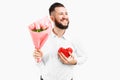 Elegant man with a beard, with a bouquet of pink tulips and a red valentine heart, a gift for Valentine`s Day Royalty Free Stock Photo
