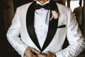 an elegant man dressing up in a white suit for his wedding, with a flower in his pocket Royalty Free Stock Photo