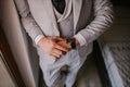 Elegant man fastening a button on a light gray  suit Royalty Free Stock Photo