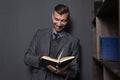 Elegant man reads book and smiles. Handsome man in suit with funny book