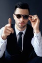 Elegant man in retro sunglasses showing thumbs up