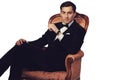 Elegant man in suit sitting on vintage armchair. Luxury.