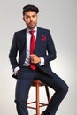 Elegant man in suit and tie sitting on a stool Royalty Free Stock Photo