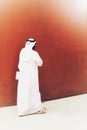 An elegant man with sunglasses and arab dresses walking on the streets of his country. Arab ethnicity concept