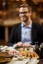 Elegant man about to dine on tasty sushi at a restaurant