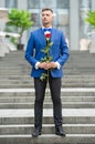 elegant man in tux. man wearing tux bowtie pose outdoor. handsome tux man with red rose