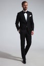 Elegant man in tuxedo standing with hand in pocket