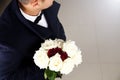 Elegant man waiting someone with beautiful bouquet of roses.