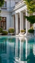 Elegant mansion with marble columns and reflective pool surrounded by lush greenery Royalty Free Stock Photo